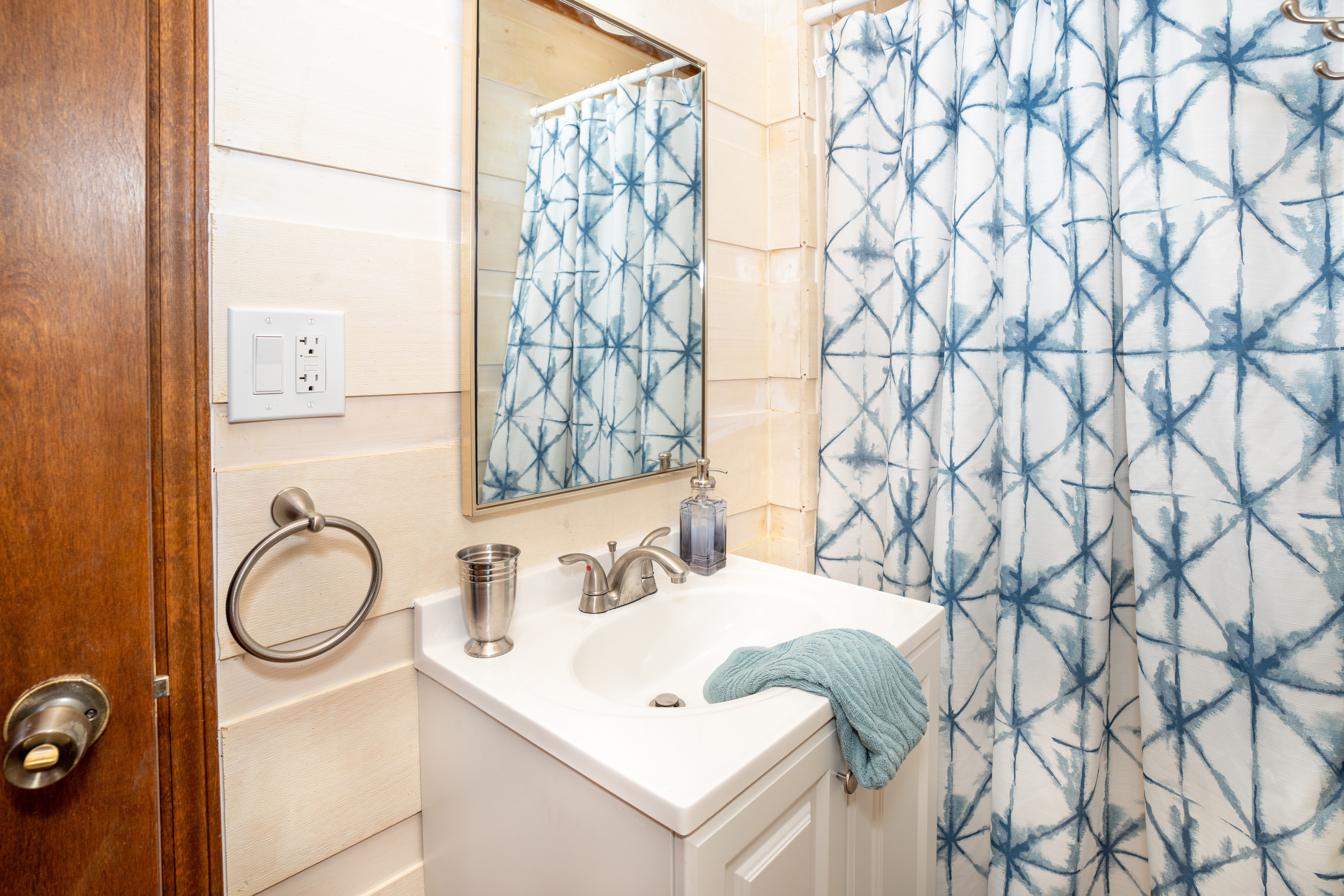 Loft Jack and Jill bathroom at Rustic Retreat with a vanity sink and a blue patterned shower curtain